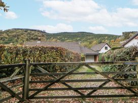 A view of a gate leading to houses and mountains at Geryllan, Rhandirmwyn near Llandovery