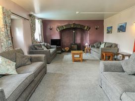 A living room with a fireplace and sofas at Glan y Gors in Dinorwic near Llanberis