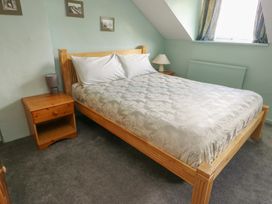 A bedroom with a bed and bedside table at Glan y Gors in Dinorwic near Llanberis