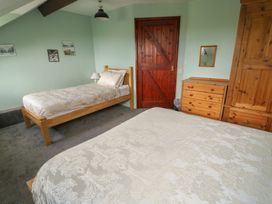 A bedroom with two beds and wooden furniture at Glan y Gors in Dinorwic near Llanberis