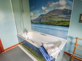 A bathroom with a bathtub and towels at Glan y Gors in Dinorwic near Llanberis
