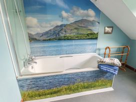 A bathroom with a bathtub and a waterfall mural at Glan y Gors in Dinorwic near Llanberis