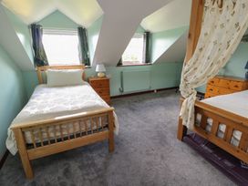 A bedroom with two beds and a lamp at Glan y Gors in Dinorwic near Llanberis