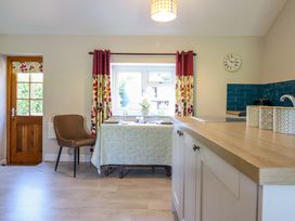 A kitchen with a table and chair near a window at Peniarth in Penybontfawr near Oswestry