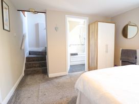 A bedroom with stairs and a bathroom door at Peniarth in Penybontfawr near Oswestry