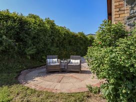 A garden with chairs and a table surrounded by hedges at Peniarth in Penybontfawr near Oswestry