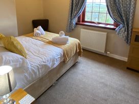 A bedroom with a bed and chair at Sea Lily New Haggerston near Holy Island
