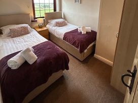A bedroom with two beds and a bedside table at Sea Lily near Holy Island
