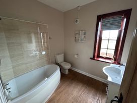 A bathroom with a bathtub, toilet, and sink at Sea Lily New Haggerston near Holy Island