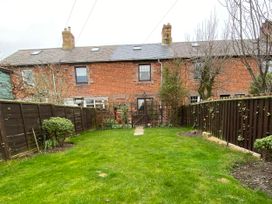 A garden with a pathway and fence at Sea Lily in New Haggerston near Holy Island