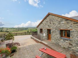 An outdoor area with a stone house and seating at Y Bwthyn near Swyddffynnon near Pontrhydfendigaid