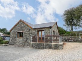 A stone house with a front door and gravel driveway at Y Bwthyn in Swyddffynnon near Pontrhydfendigaid