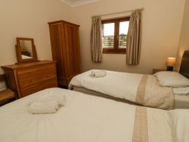 A bedroom with two beds and wooden furniture at Y Bwthyn in Swyddffynnon near Pontrhydfendigaid