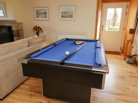 A pool table with cue stick and balls in a snug at Granary Stone House in Embleton