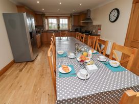 A kitchen with a long dining table set for breakfast at Granary Stone House in Embleton