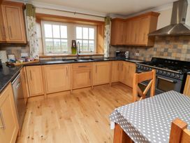 A kitchen with cabinets and appliances at Granary Stone House in Embleton