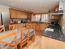 A kitchen with wooden cabinets and an island at Granary Stone House in Embleton