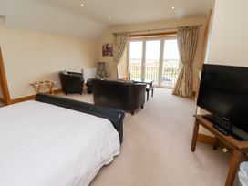 A bedroom with a bed and seating area at Granary Stone House in Embleton
