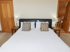 A bedroom with a bed and nightstands at Granary Stone House in Embleton