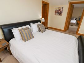 A bedroom with a bed and lamp at Granary Stone House in Embleton