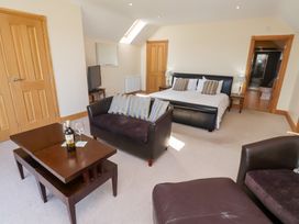 A bedroom with a bed and sofa at Granary Stone House Embleton