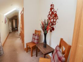 A hallway with chairs, a table, and wall decorations at Granary Stone House in Embleton