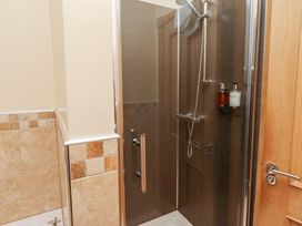 A shower enclosure with a sliding door at Granary Stone House in Embleton