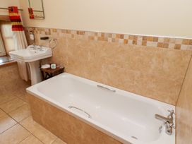 A bathroom with a bathtub and sink at Granary Stone House in Embleton