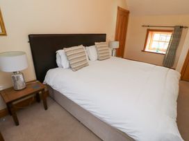 A bedroom with a bed and bedside lamp at Granary Stone House in Embleton
