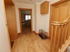 A hallway with a staircase and storage at Granary Stone House in Embleton