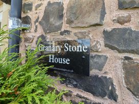 A sign on a stone wall for Granary Stone House in Embleton