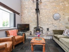 A living room with a wood stove and furniture at Pear Tree Cottage Mark near Burnham-on-Sea