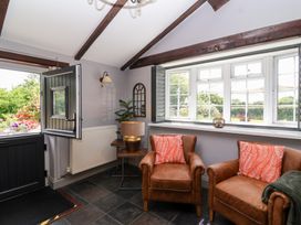 A room with two armchairs and a table at Pear Tree Cottage Mark near Burnham-on-Sea