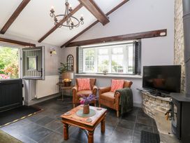 A living room with chairs and a television at Pear Tree Cottage Mark near Burnham-on-Sea