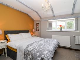 A bedroom with a bed and window at Pear Tree Cottage Mark near Burnham-on-Sea