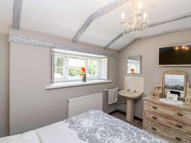 A bedroom with a bed and window at Pear Tree Cottage Mark near Burnham-on-Sea