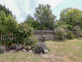 A garden with a fence and flowers at Pear Tree Cottage Mark near Burnham-on-Sea