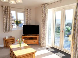 A living room with a television and sliding doors at Heather Croft in Robin Hood's Bay