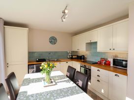 A kitchen with cabinets, a sink, and a table at Heather Croft in Robin Hood's Bay
