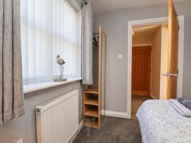 A bedroom with a window, wardrobe, and wooden door at Heather Croft in Robin Hood's Bay