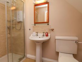A bathroom with shower, sink, toilet, and mirror at Heather Croft in Robin Hood's Bay