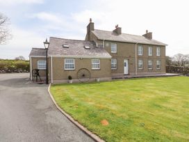 A detached house with multiple windows a lawn and a driveway at Garreg Wen Isaf Bach in Penygroes near Caernarfon