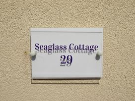 A sign with 'Seaglass Cottage 29' on a wall at 29 High Street Aldeburgh
