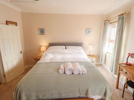 A bedroom with a bed, bedside table and lamp at 29 High Street in Aldeburgh