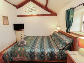 A bedroom with a bed and television at Sonya's Cottage Anthorn, Solway Firth
