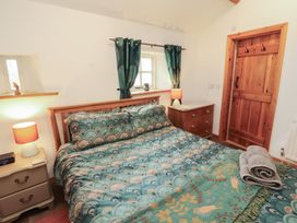 A bedroom with a bed and nightstand at Sonya's Cottage Anthorn, Solway Firth