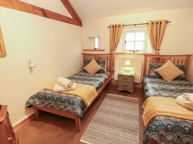 A bedroom with two beds and a bedside table at Sonya's Cottage Anthorn, Solway Firth