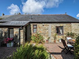 An outdoor area with stone wall and furniture at Poldark Cottage in East Taphouse