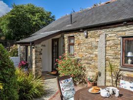 A cottage exterior with a table and chairs in East Taphouse