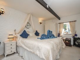 A bedroom with a bed and window at Poldark Cottage East Taphouse